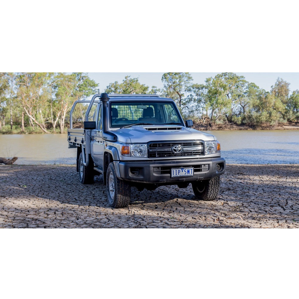The OME 2.5 inch Lift Kit for Landcruiser 79 Series (2010-ON), equipped with the renowned Old Man Emu suspension system, is parked next to a river.