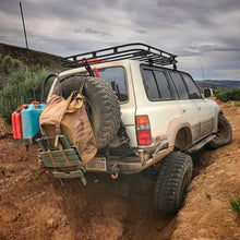 Load image into Gallery viewer, A Toyota Land Cruiser equipped with an OME 2 inch Lift Kit for Lexus LX450 (96-97), providing increased ground clearance, is parked in a muddy area.