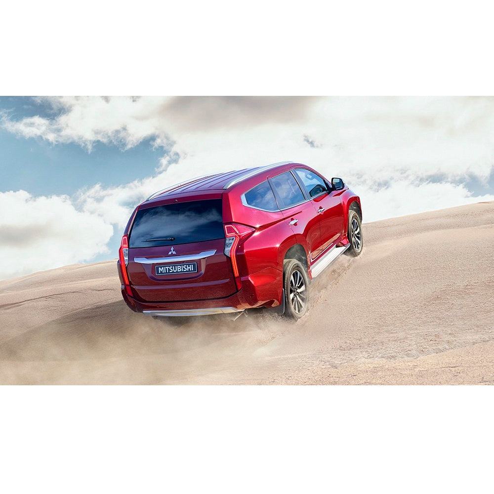The red 2019 Mitsubishi Pajero, equipped with the OME 2 inch Lift Kit for Montero Sport (15-21) by Old Man Emu, confidently navigates through the desert with its impressive ground clearance.
