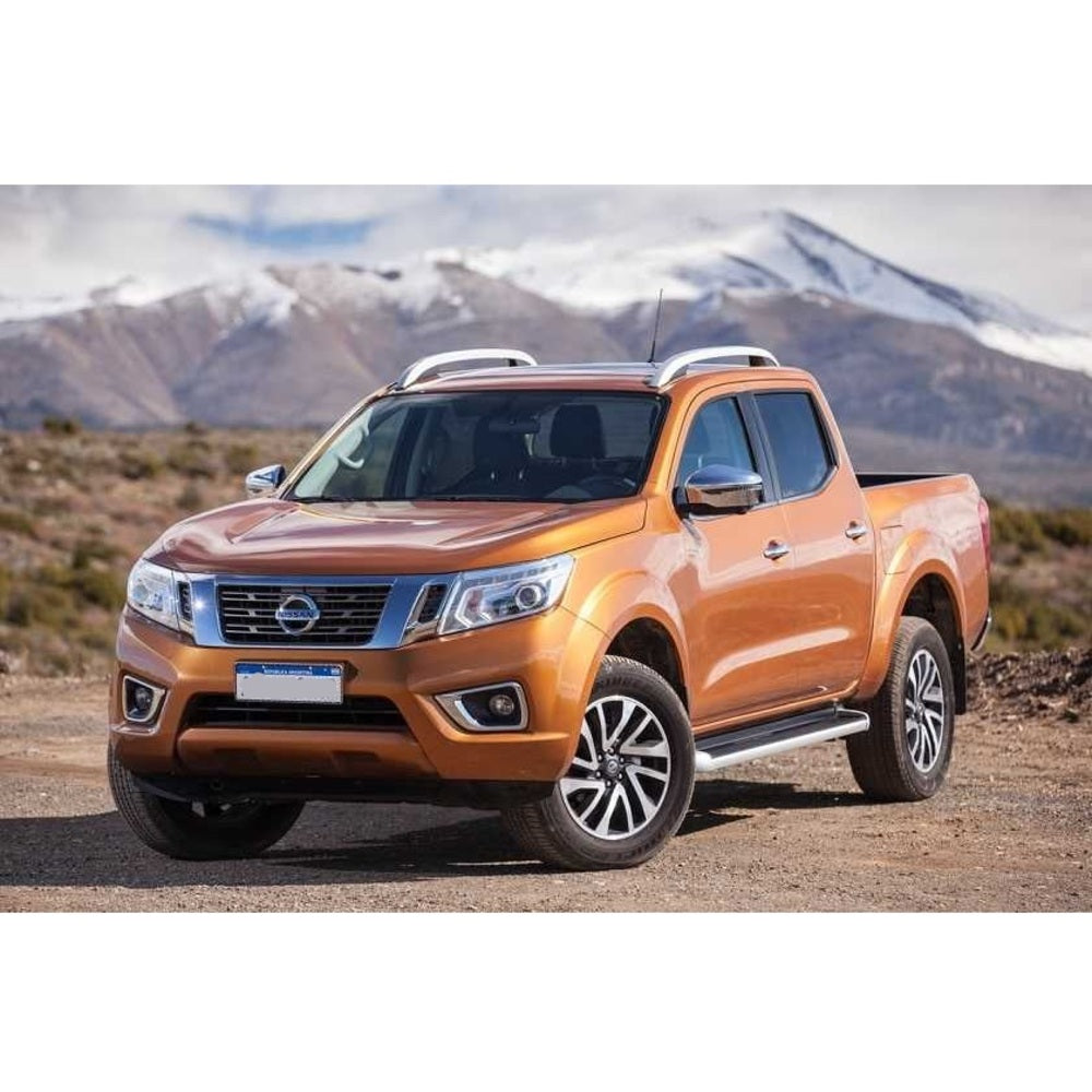 The orange Old Man Emu Nissan Frontier showcases an impressive ground clearance as it is parked on a dirt road.
