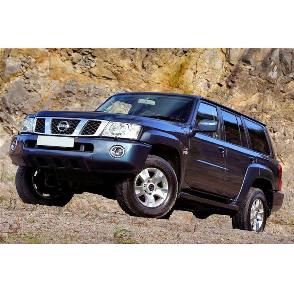 An Old Man Emu-equipped blue Nissan Armada with exceptional ground clearance and an OME 2 inch Lift Kit for Patrol Y61 (99-09) is parked in front of a rocky area.