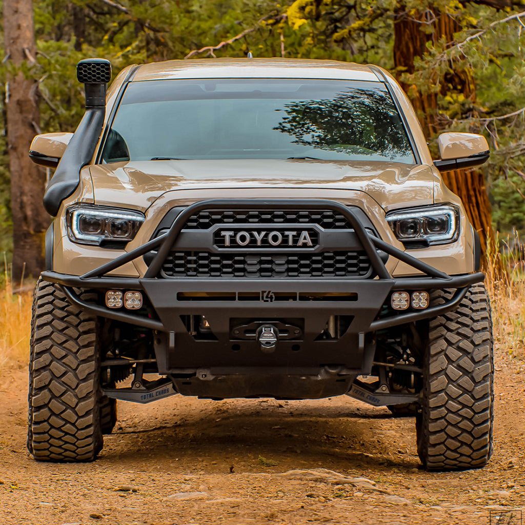 The front end of a Toyota Tacoma equipped with an Old Man Emu 2 inch Essentials Lift Kit for Tacoma (16-23) suspension system and Nitrocharger shocks.