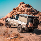 An Old Man Emu 2 inch Lift Kit for Tacoma (98-04) with an enhanced suspension articulation parked on a rock in the desert.