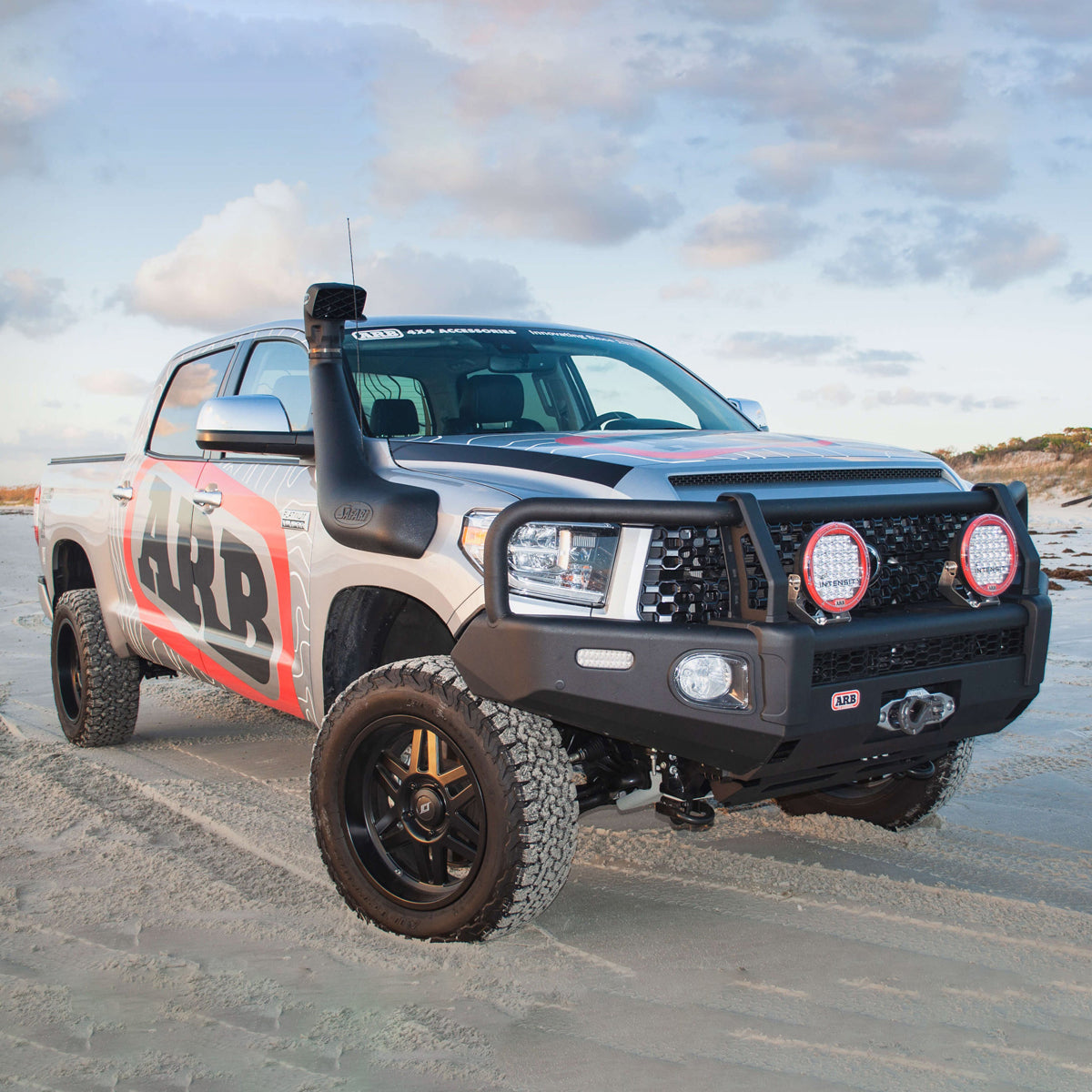 A Toyota Tundra equipped with an OME 2.5 inch Lift Kit for Tundra (07-21) and Nitrocharger shocks is parked on the beach.