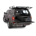 An ARB pickup truck with maximum security and an anti-rattle design, featuring an ARB Outback Solutions Roller Drawer RD945 storage compartment in the back.