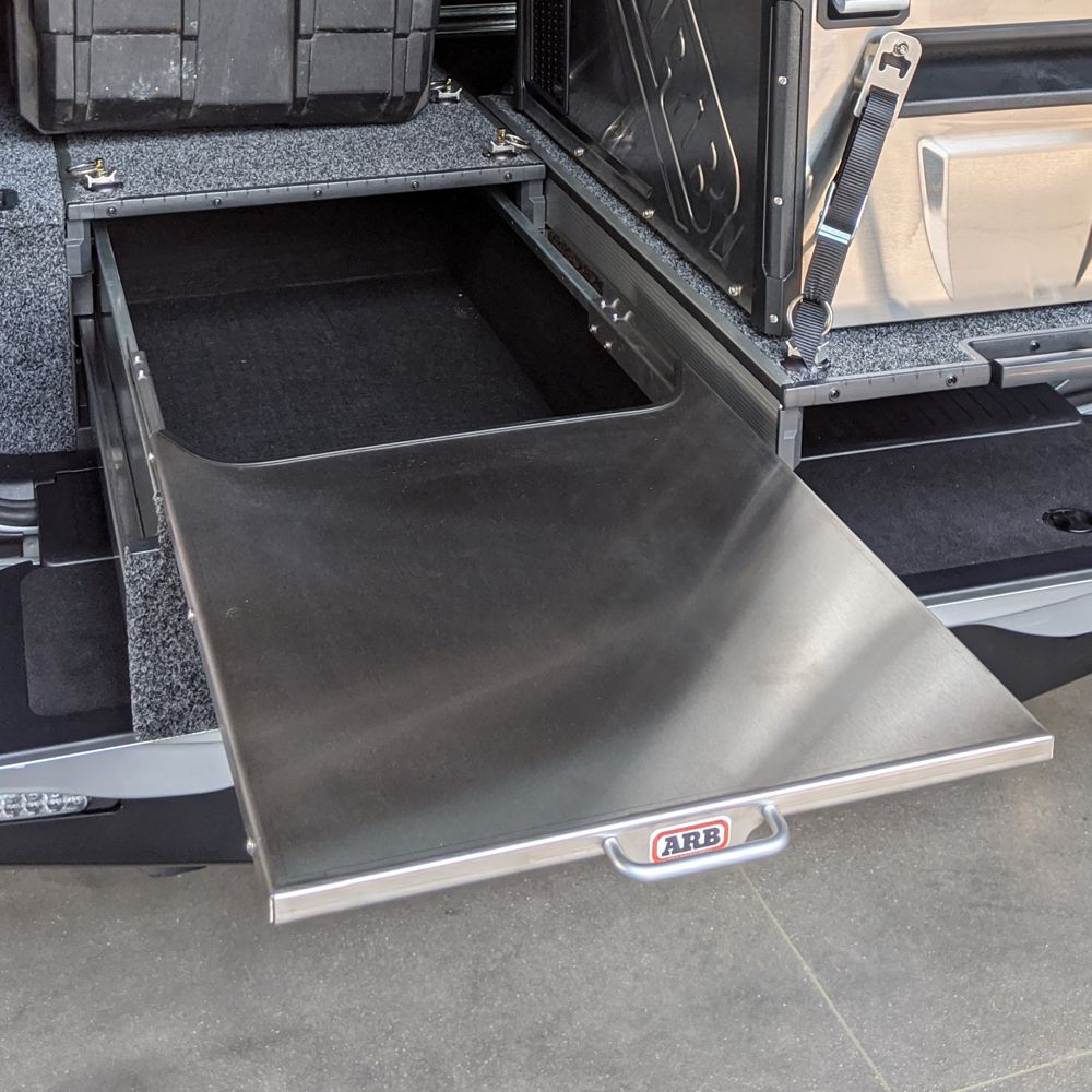 A silver van with an ARB Roller Drawer Table RDTAB1355 storage compartment in the back.