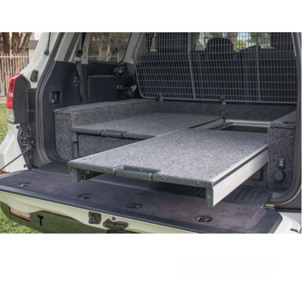 The back of a SUV with an ARB Outback Solutions Mid-Height Roller Floor RFH945 featuring an anti-rattle design for maximum security and being dust and water resistant.