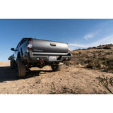 Body Armor 05-15 Toyota Tacoma Pro Series Rear Bumper in black steel with integrated shackle mounts on off-road terrain