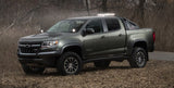 Baja Designs Squadron Pro GM A-Pillar Mount Kit installed on lifted 2016 Chevrolet Colorado with off-road tires and LED light bar