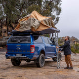 ARB Flinders Rooftop Tent 803300A mounted on blue 2021 Ford Ranger with off-road tires and aluminum ladder deployment