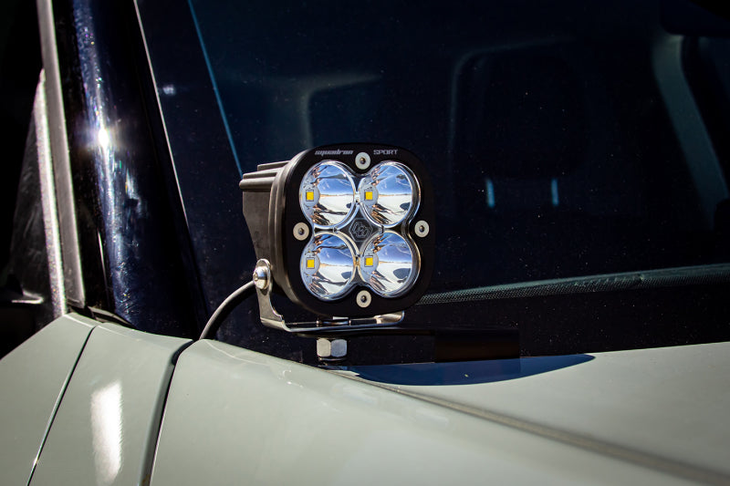 Baja Designs 21+ Ford Bronco Sport Squadron Pro Spot LED Light Pods - Clear mounted on vehicle hood bracket with wiring harness