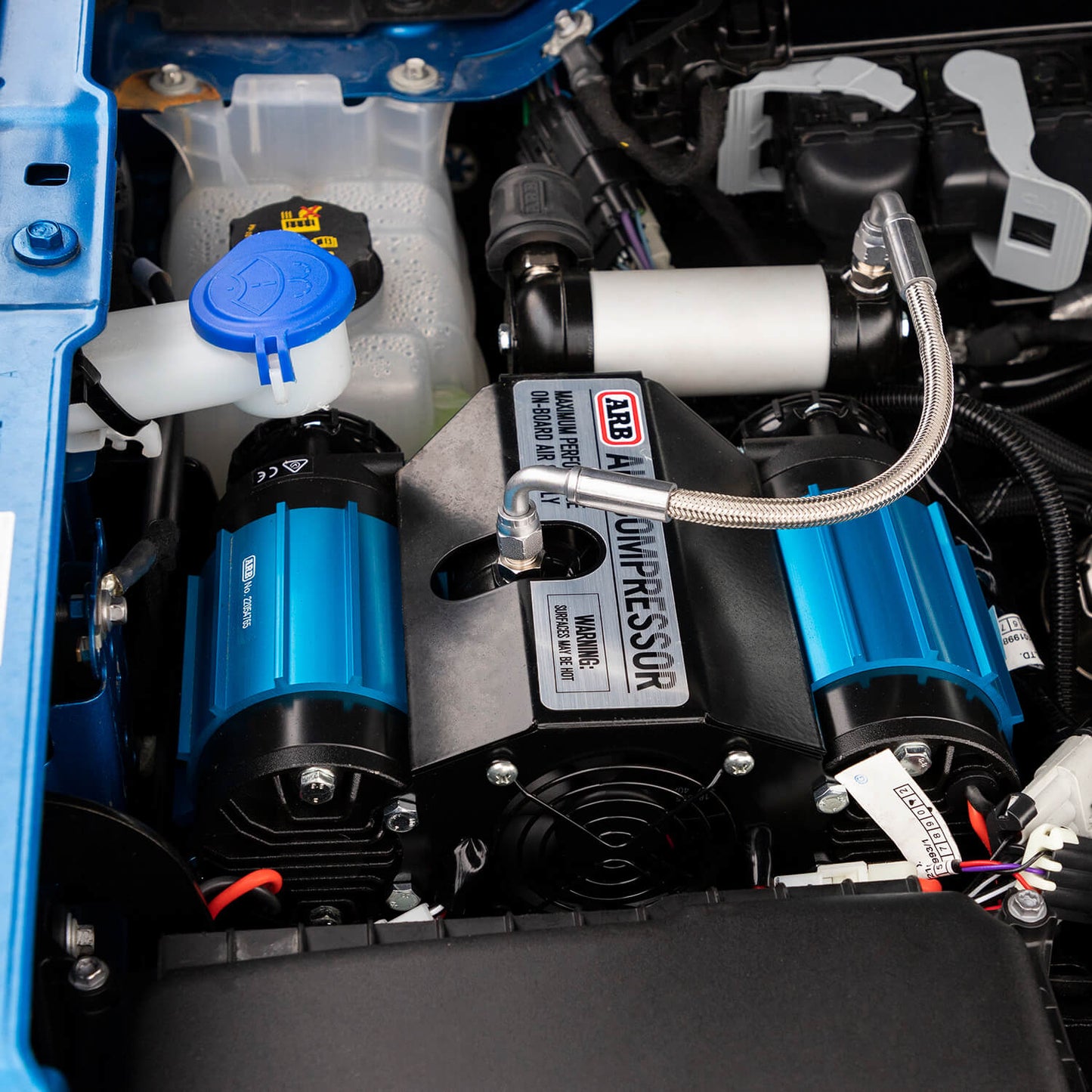 ARB Twin 12V Onboard Compressor Kit CKMTA12BK1 installed in 2007-2018 Jeep Wrangler JK engine bay with high-strength materials