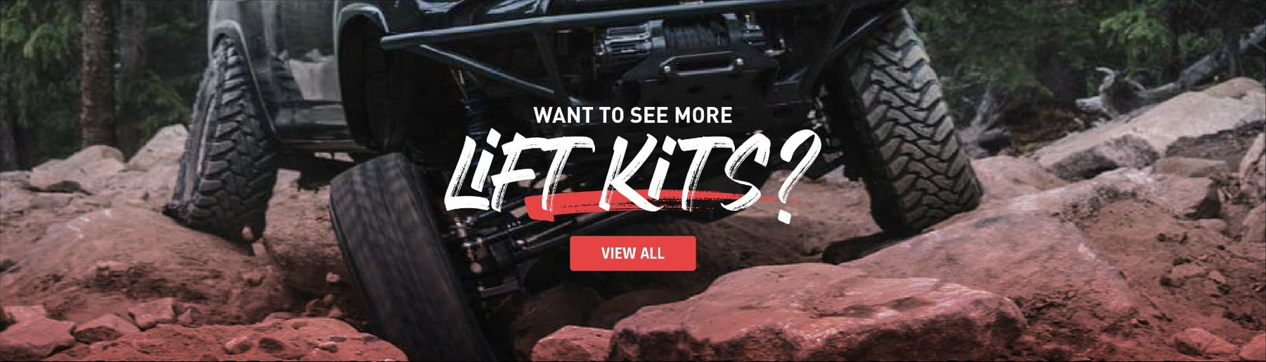 Off-road vehicle navigating rocky terrain with lifted suspension and oversized all-terrain tires in forest setting