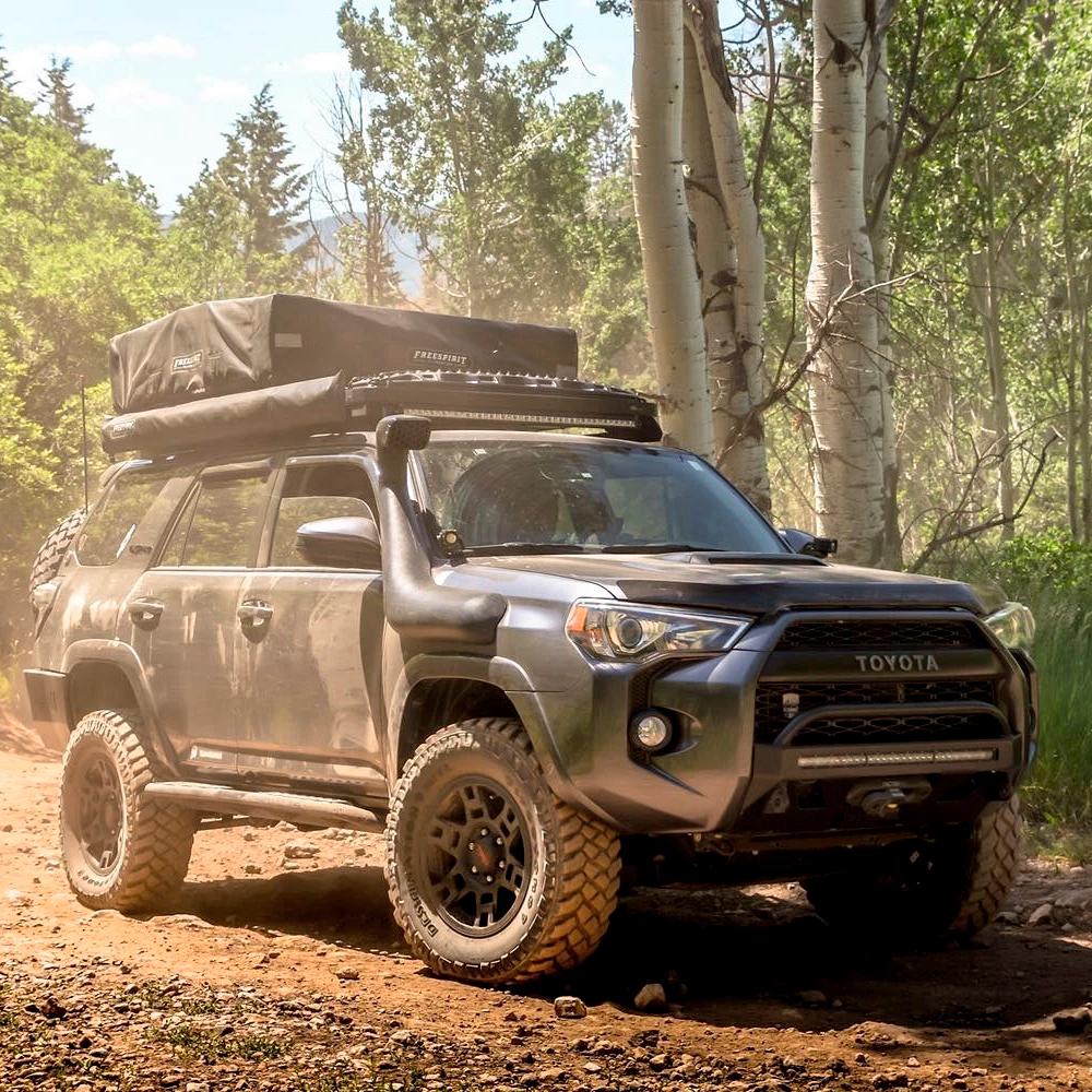 The Old Man Emu Toyota 4Runner, a reliable off-road vehicle, is parked in the woods.