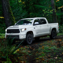 Load image into Gallery viewer, The 2019 Toyota Tundra, known for its off-road performance, smoothly maneuvers through the woods with the help of its Old Man Emu BP-51 shock absorbers and adjustable damping.