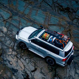 An Old Man Emu Toyota Land Cruiser, equipped with ARB Old Man Emu Front Coil Springs 2888 for Toyota 4Runner, Prado 150 Series, Tacoma, Hilux for enhanced suspension, is parked on a rocky beach. Its oxidation protection ensures durability against corrosive elements, while its easy installation makes it convenient for usage.