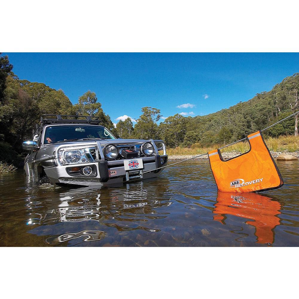 An ARB 4-wheel drive truck is in the water with an orange ARB Recovery Winch Damper ARB220 bag attached to it.
