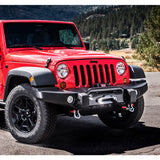 The red Old Man Emu jeep wrangler boasts impressive ground clearance and OME Adjustable Front Lower Control Arms LCAJKFR as it is parked in front of a mountain.