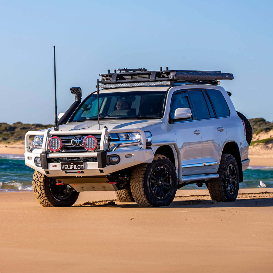 An Old Man Emu ARB Front Strut Top Hat Kit OMETH003 (pair) is parked on the beach, showcasing its impressive shock absorber for exceptional low-speed control.