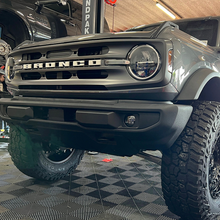 Load image into Gallery viewer, An black Old Man Emu Ford Bronco with modified ride height, achieved through the installation of ARB Old Man Emu Rear Coil Springs 3206, is parked in a garage.