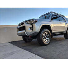 Load image into Gallery viewer, The Toyota 4Runner, equipped with the ARB Under Vehicle Skid Plates System with kinetic (KDSS) 5421110, is parked in a parking lot.