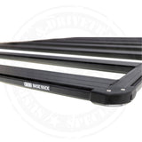A black Base Rack For Toyota FJ Cruiser 2007-2016 ARB 1770040 with mount brackets on a white background.