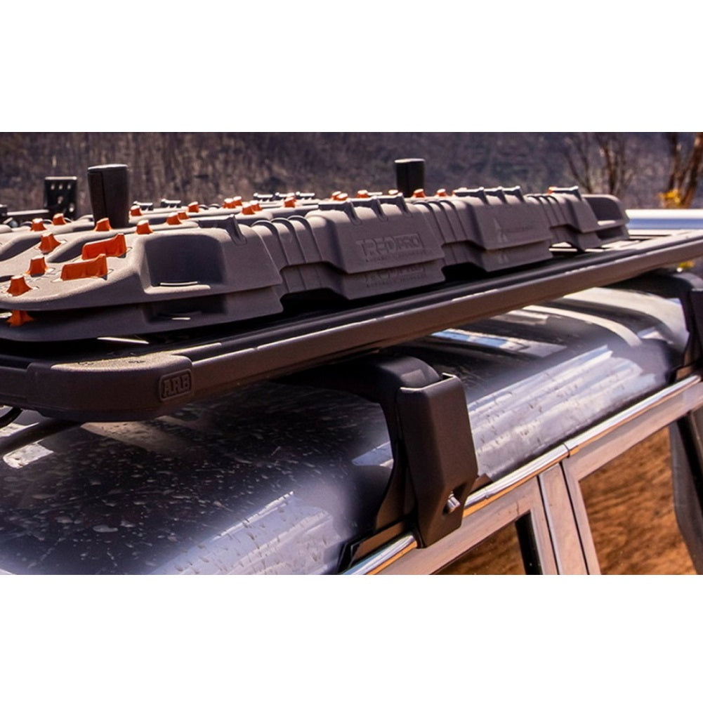 A car equipped with the ARB Base Rack Gutter Mount Kit ARB 17900010, featuring steel gutter runners and support plates.