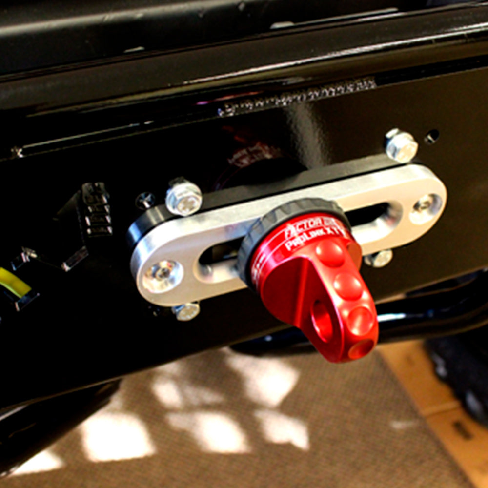 A close up of a red handle on a black motorcycle featuring a Factor 55 ProLink XXL Shackle Mount Assembly in Red 00210-01.