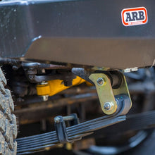 Load image into Gallery viewer, A close up of a black truck with the ARB OME Rear Leaf Spring Shackle OMEGS12 on the rear bumper for enhanced ride quality.