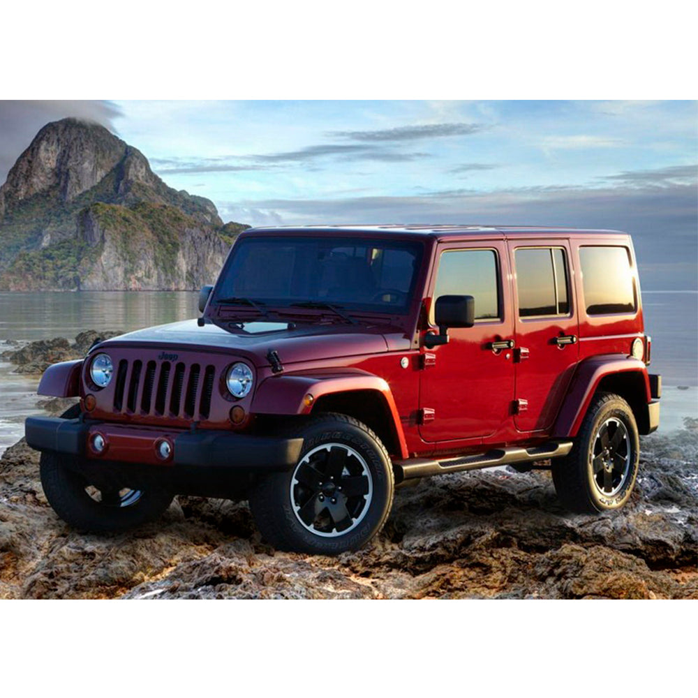 A red Old Man Emu Jeep Wrangler JK (4-Door) with adjustable Old Man Emu control arms parked on a rocky beach.