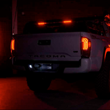 A Morimoto XB Led Tails LF702 For Toyota Tacoma (2016 - 2022) truck is lit up at night.