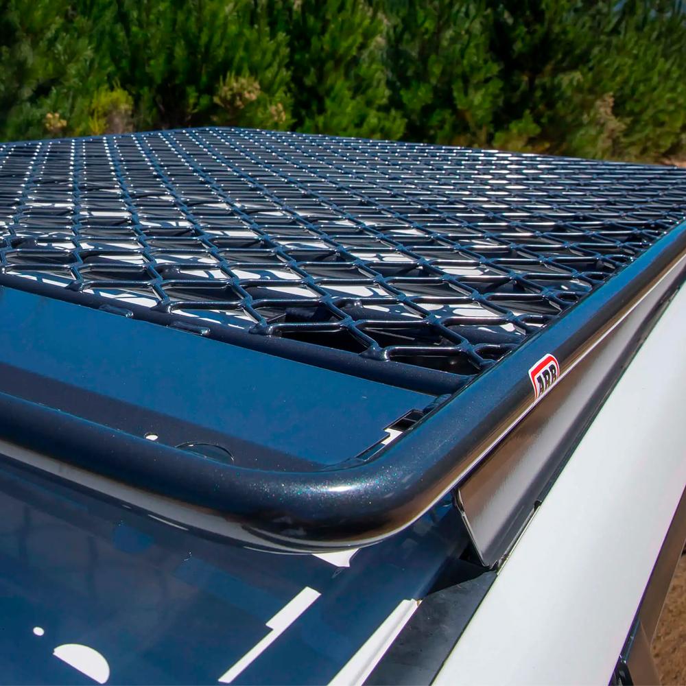The car features an ARB Alloy Flat Rack 87”X 49” with Mesh Floor ARB 4900060M equipped with a fitting kit for steel support channels, providing secure storage options.