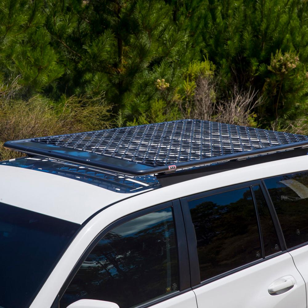 A white ARB SUV with a secure storage compartment and an ARB fitting kit for the solar panel on top of it.