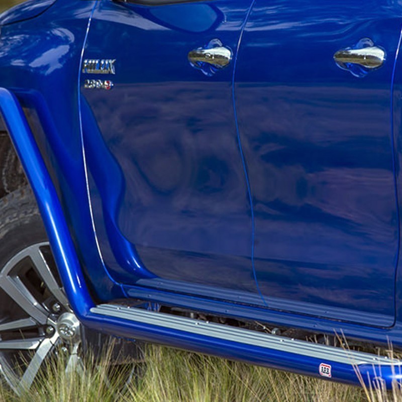 A blue ARB Summit Step Section For Toyota Hilux Revo/Rocco (2015-2022) 4414620 parked in a field, offering budget-friendly pricing.