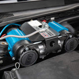 An ARB 12 Volts On-Board Twin High Performance Air Compressor 12V- CKMTA12 equipped in the trunk of a car for on-the-go inflation needs.