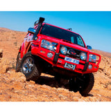 A red Toyota Tacoma with Old Man Emu BP-51 suspension and shock absorbers is driving through a desert.