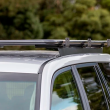 Load image into Gallery viewer, A Toyota Land Cruiser 200 Series with an ARB Alloy Flat Rack With Mesh Floor on top of it, offering maximum protection and airbag compatibility while maintaining a favorable approach angle.