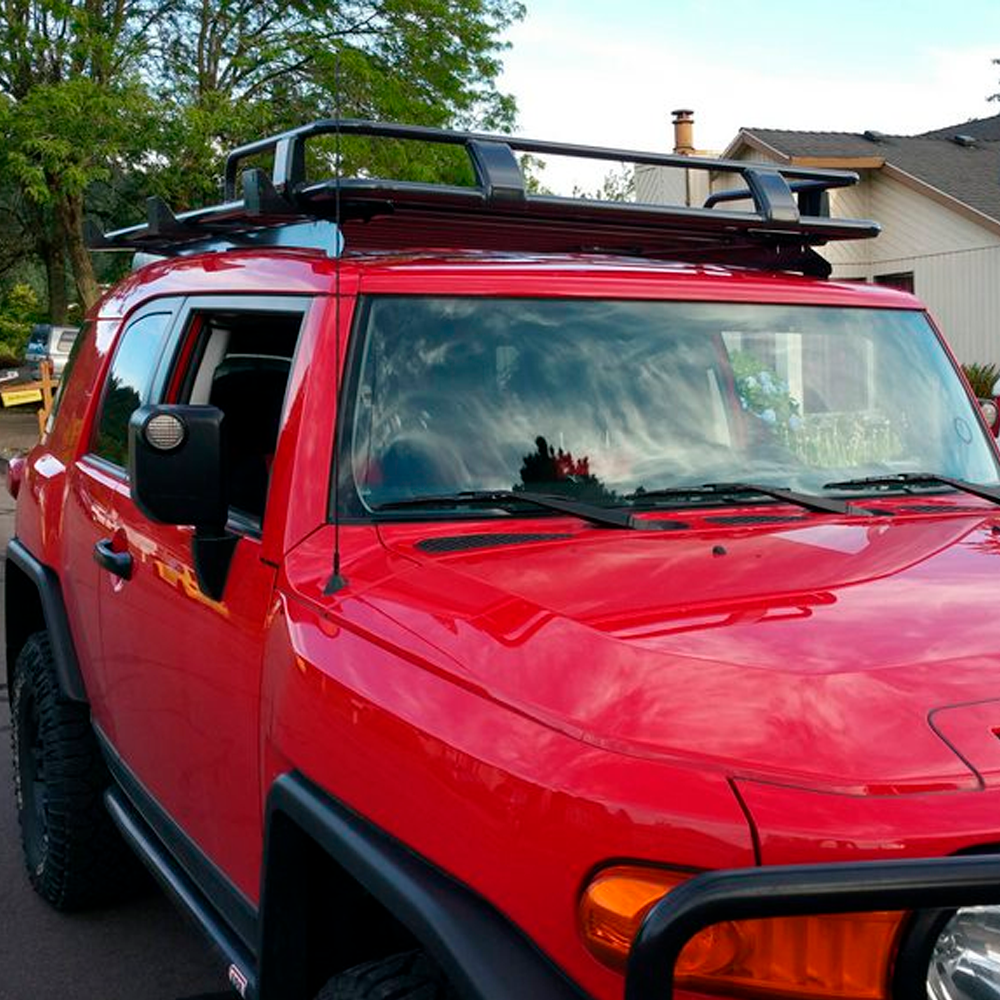 A red ARB Touring Roof Rack FJ Cruiser (2007-2009) 3800200KLC2 equipped with a high-quality roof rack, enhancing the vehicle's load capacity.