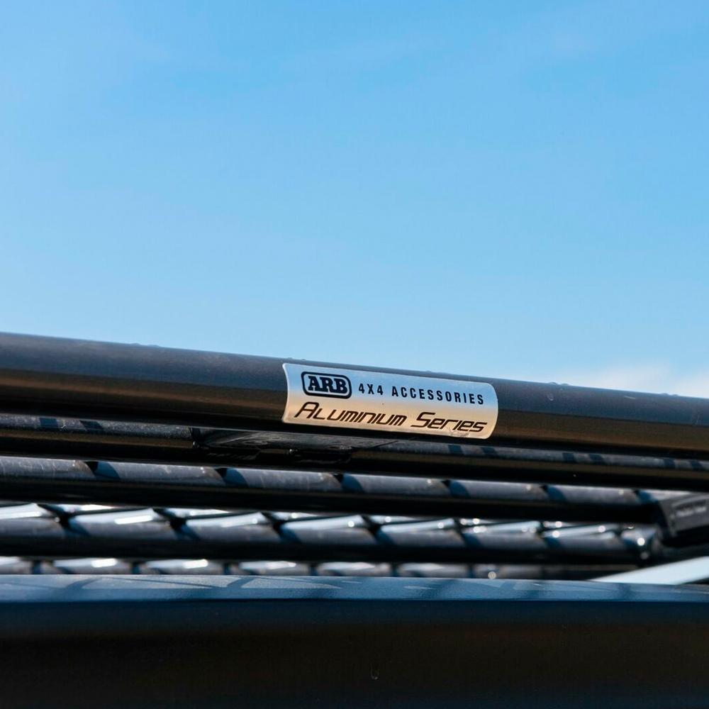 A close up of a black ARB roof rack with a fitting kit.