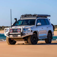 Load image into Gallery viewer, A white ARB Alloy Flat Rack With Mesh 87”X 44” for Toyota Land Cruiser 200 Series 2008 - 2020, known for its steel construction and maximum protection, parked on the beach.