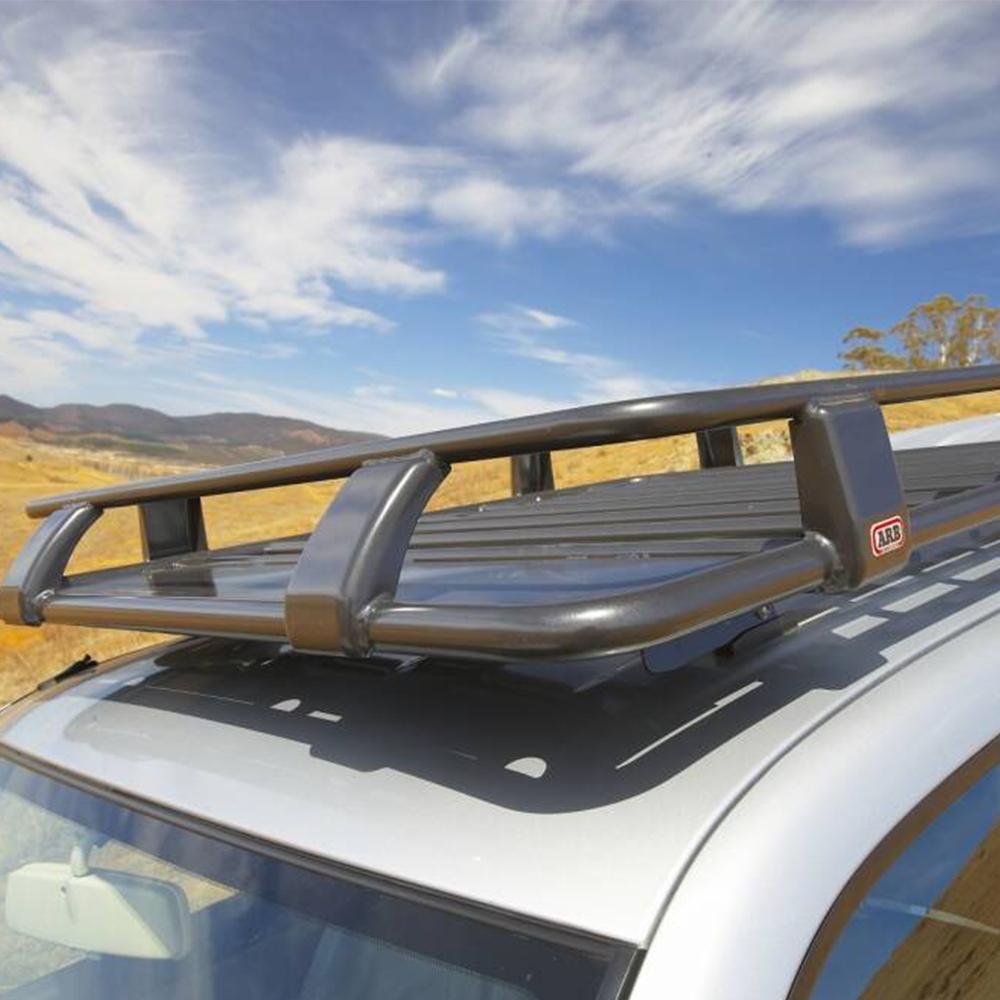 A car with a ARB Roof Rack Fitting Kit for Toyota Hilux DCab 1997-2011 (product name) on top of it, providing secure storage and high capacity for transporting items.