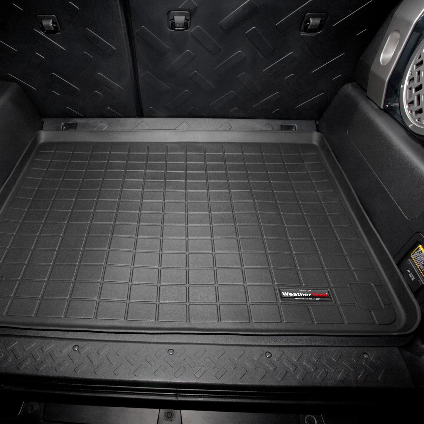 A black Weathertech Cargo Liner for Toyota FJ Cruiser (2007-2016) in the back of a suv, designed to meet FMVSS302 safety standards and offering superior protection like WeatherTech cargo liners.