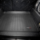 A black Weathertech Cargo Liner for Toyota FJ Cruiser (2007-2016) in the back of a suv, designed to meet FMVSS302 safety standards and offering superior protection like WeatherTech cargo liners.