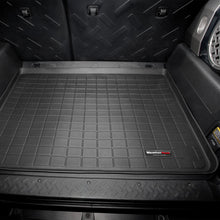 Load image into Gallery viewer, A black Weathertech Cargo Liner for Toyota FJ Cruiser (2007-2016) in the back of a suv, designed to meet FMVSS302 safety standards and offering superior protection like WeatherTech cargo liners.