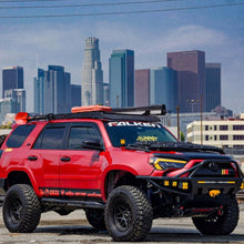 Load image into Gallery viewer, A durable red Fox Racing 2.0 Series Smooth Body Reservoir Shock 985-24-117 for Toyota 4Runner 2010 - 2014 is parked in front of a city skyline.