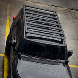 A black jeep wrangler with a Base Rack For Toyota FJ Cruiser 2007-2016 ARB 1770040 is parked in a parking lot.
