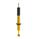 A yellow Old Man Emu shock absorber on a white background, showcasing its compression valving for enhanced ARB Old Man Emu Front Nitrocharger Sport Shock 90017 performance.