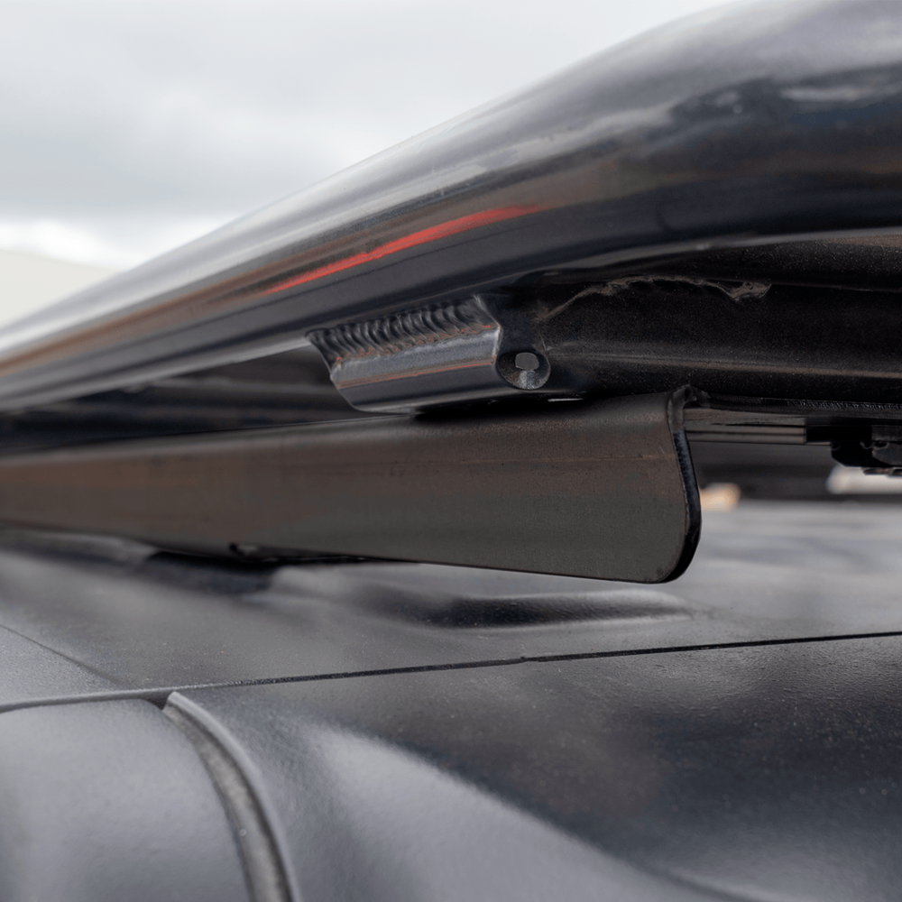 A black car with an Alloy Flat Rack With Mesh Floor for Toyota Land Cruiser 200 Series ARB 4900040MKLC2 attached to it, providing maximum protection and airbag compatibility.