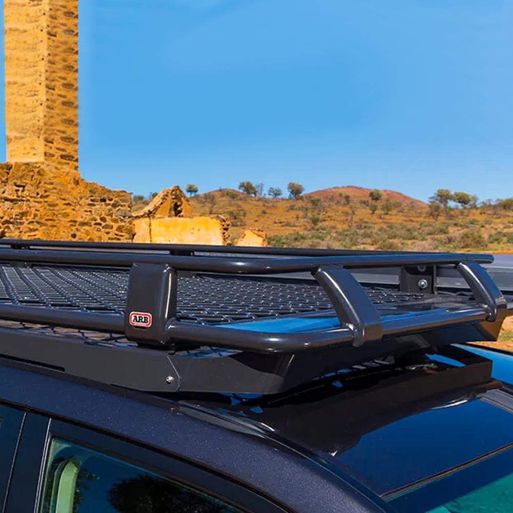 A black SUV fitted with a Steel Basket Rack Kit 87” X 44” for Land Cruiser 200 Series 2008 - 2021 from ARB, providing secure storage and high capacity.