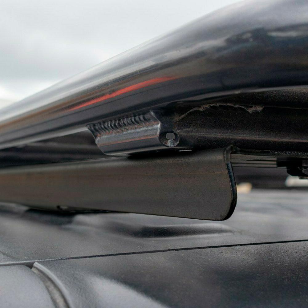 A black car with an ARB Alloy Flat Roof Rack 70” x 44” with Mesh Floor for Jeep Wrangler JL 2018-2019 securely attached to it, perfect for safe and convenient storage.